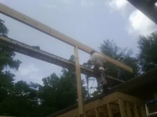Carpenter setting a ridge beam over a new addition frame — Ice Dam Removal by Roofing Brothers in Haworth