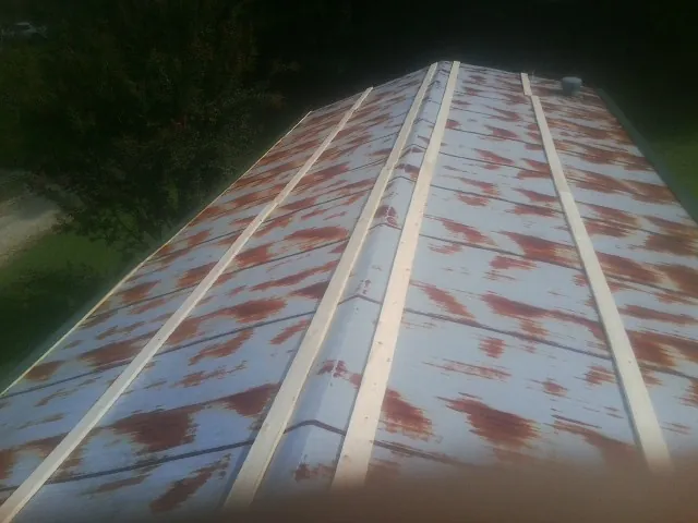 Rusted metal roof panels with new wood purlins before replacement — Storm Damage Roof Repair in Haworth by Roofing Brothers