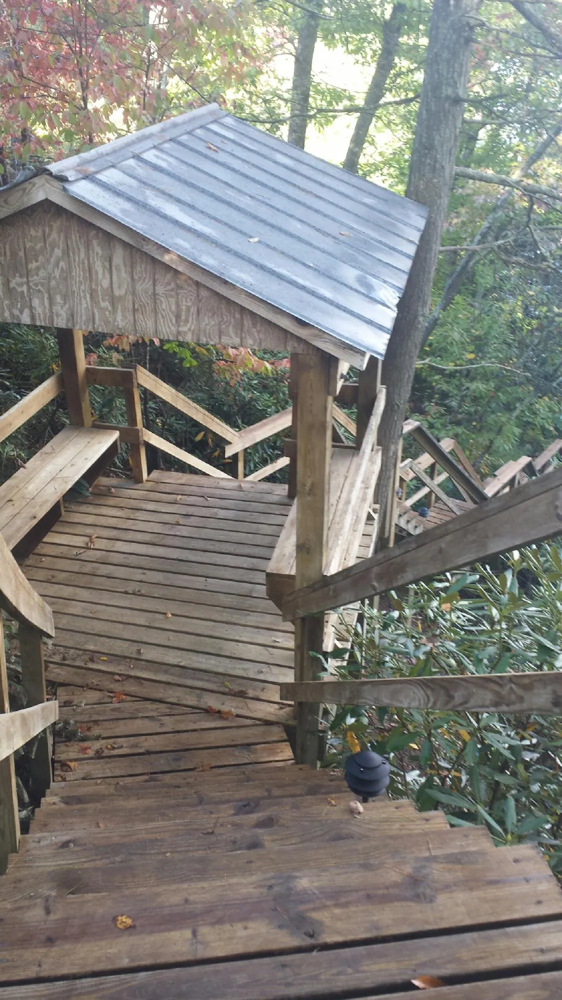Metal roofed shelter over wooden steps on a wooded walkway — Skylight Repair & Installation work by our crew in Haworth