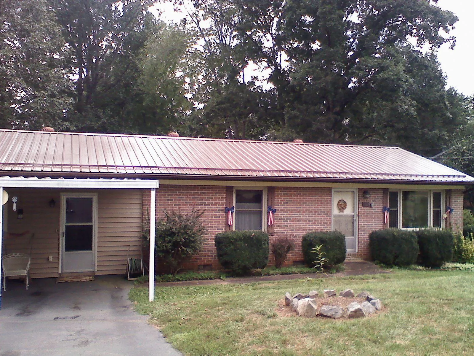 Bronze metal roof and carport on a brick ranch home — Roof Repair work by our crew in Haworth